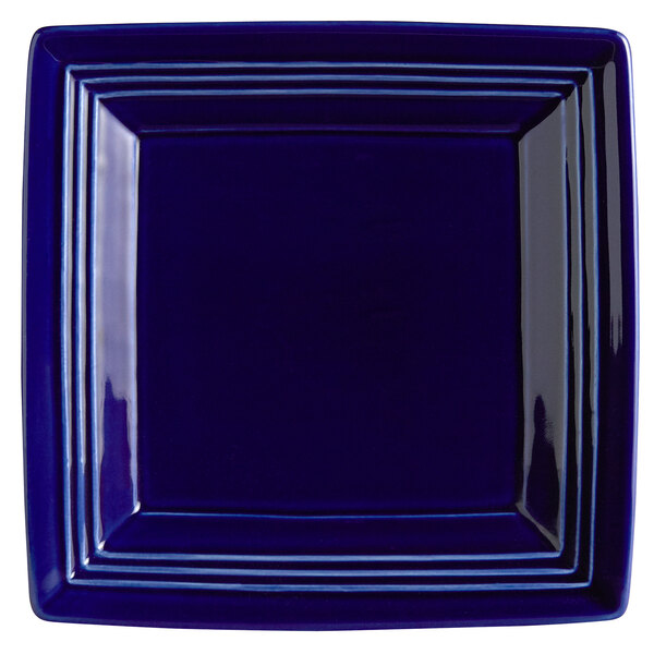 A white square Tuxton Concentrix china plate with a blue border.