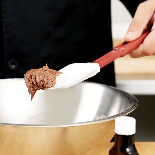A silicone scraper spoon scooping batter