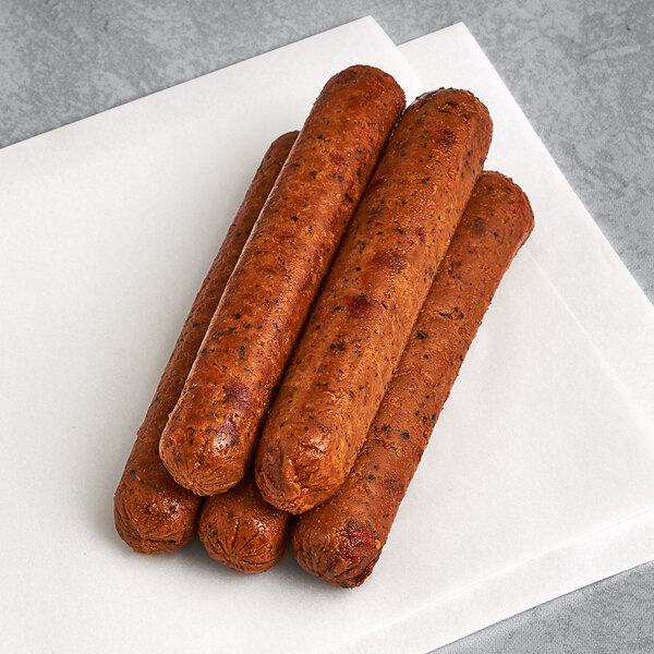 Three Tofurky Italian sausages on a white napkin.