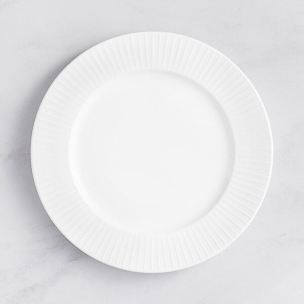 An Acopa Cordelia white porcelain plate with an embossed circular pattern on the rim.