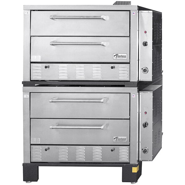A stack of silver Peerless quadruple deck pizza ovens with side controls.