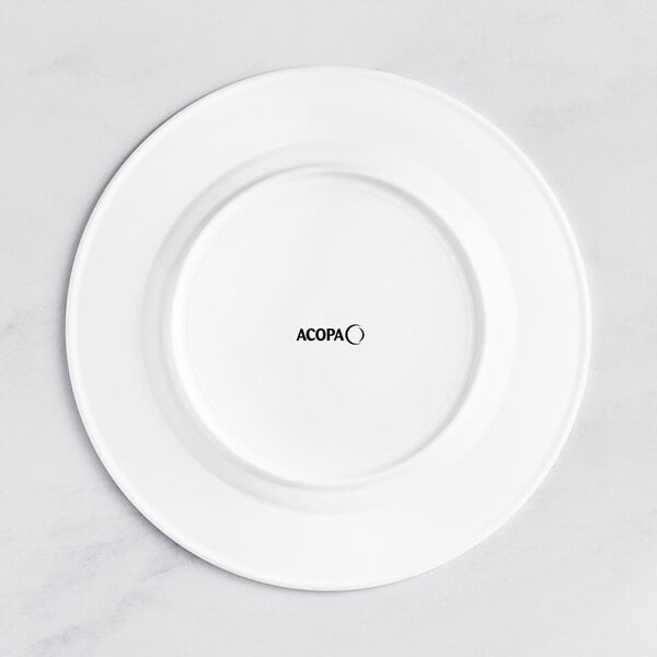 An Acopa Cordelia white porcelain plate with an embossed wide rim and black text on it.