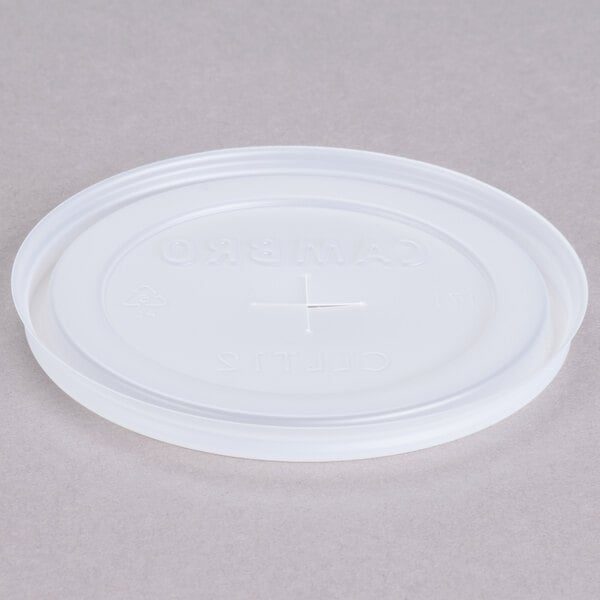 A white plastic lid with a straw slot and a cross.