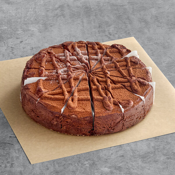 A brown Eli's Cheesecake with a cut out center on a piece of paper.