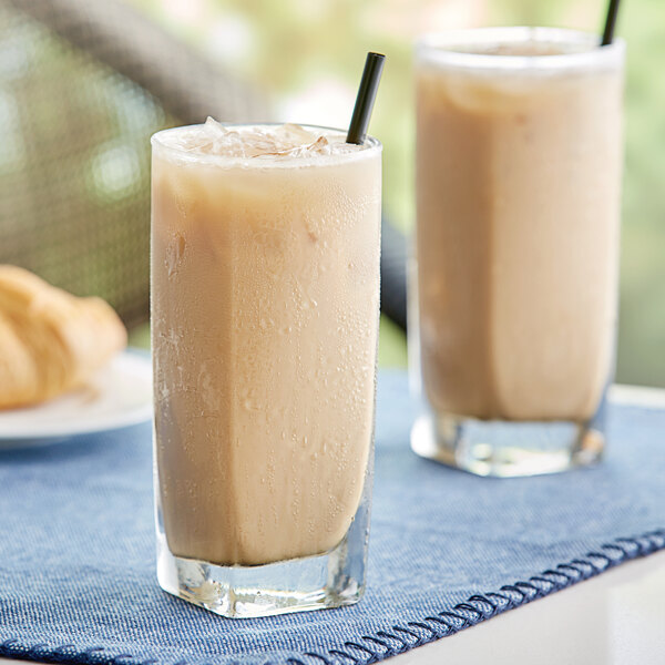 Two glasses of David Rio Power Chai Tea Latte on a table.