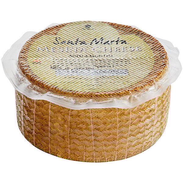 A round basket of Santa Marta Manchego-style cheese wrapped in plastic.