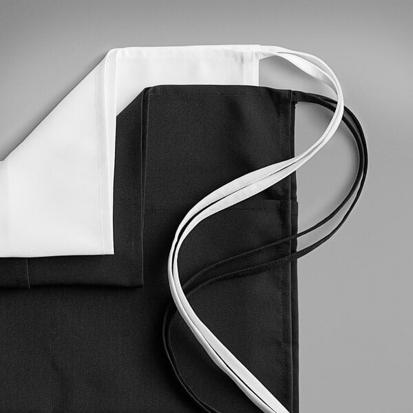 A white polyester waist apron with three pockets and white ties.