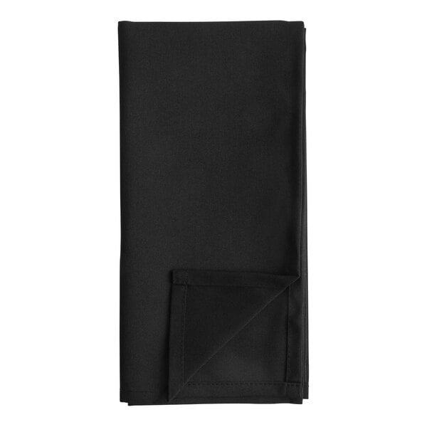 A black folded cloth napkin on a white surface.