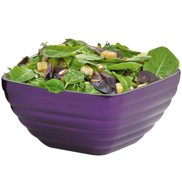 A Vollrath Passion Purple metal bowl filled with salad greens.