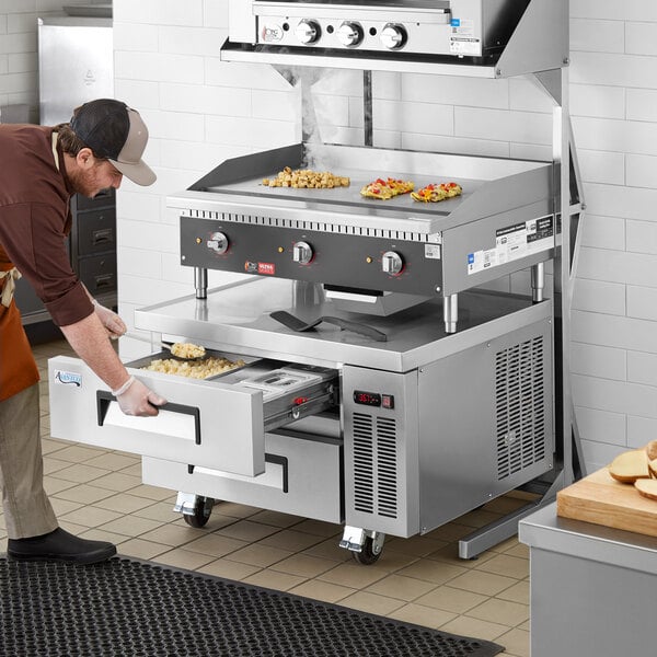 A man using the Cooking Performance Group Ultra Series countertop electric griddle in a professional kitchen.