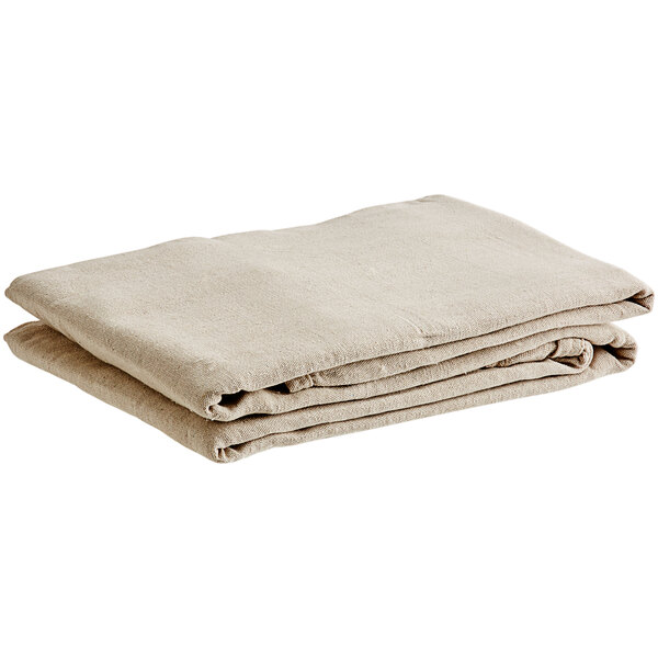 A stack of folded beige Monarch Brands canvas drop cloths on a white background.