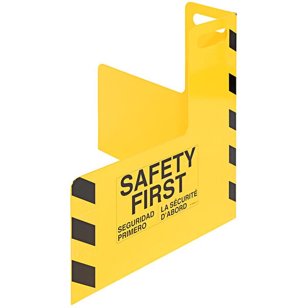 A white steel corner guard with a yellow safety sign and black stripes on it.