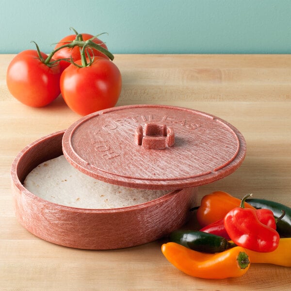 A red HS Inc. polyethylene tortilla server with food inside and an open lid on a table with tomatoes.