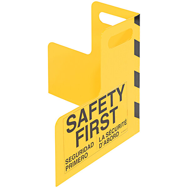 A yellow steel corner guard with black and blue safety signs and handles.