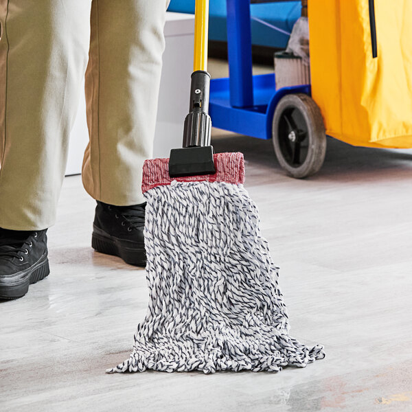 A person using a Lavex Blue and White Wet Mop to clean a floor.