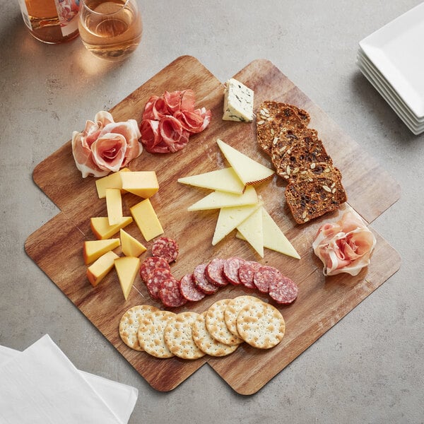 An Enjay wood laminated box filled with cheese, meat, and crackers on a table.