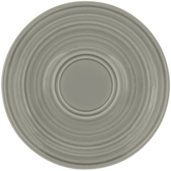 A grey saucer with a circular pattern.