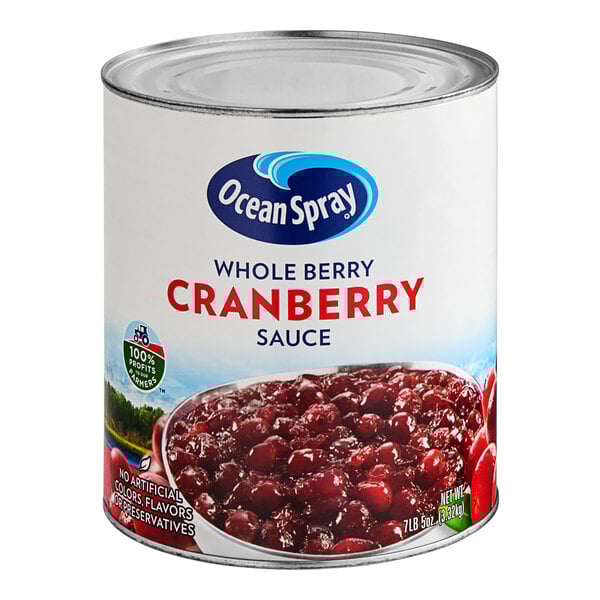 A white #10 can of Ocean Spray Whole Berry Cranberry Sauce with a bowl of cranberries.