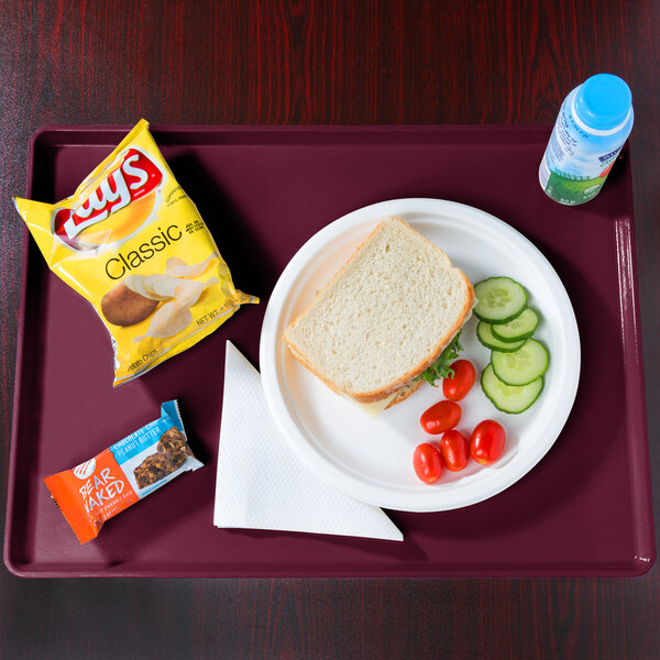 A Cambro dietary tray with a plate of food, a sandwich, and a bottle of water.