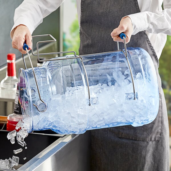 A woman using a Vigor aluminum ice tote to carry a large bucket of ice.
