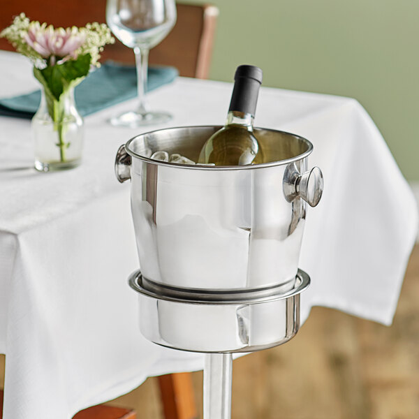 An Acopa wine bucket holding a wine bottle on a table.