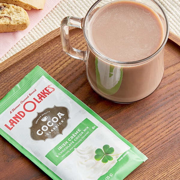 A glass of hot Land O Lakes Irish Creme and Chocolate Cocoa next to a packet of chocolate.