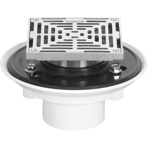 A white Josam PVC floor drain with a metal Nikaloy grate over a black circle.