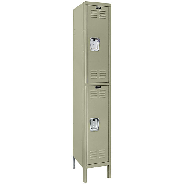 A tan metal Hallowell locker with two tiers and two doors.
