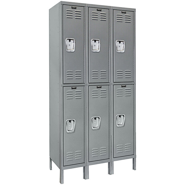 A group of grey Hallowell triple tier lockers with recessed handles.