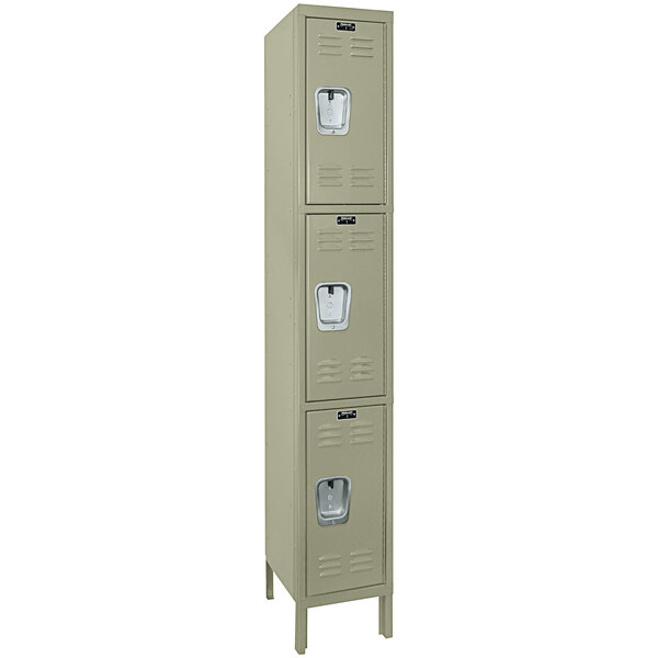 A tan metal Hallowell single locker with three doors.