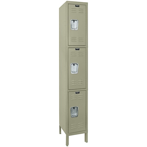 A tan metal Hallowell locker with three doors.