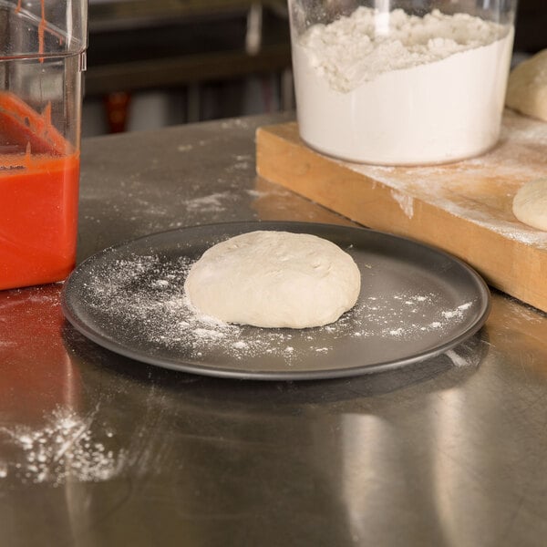 A ball of dough on a black surface.