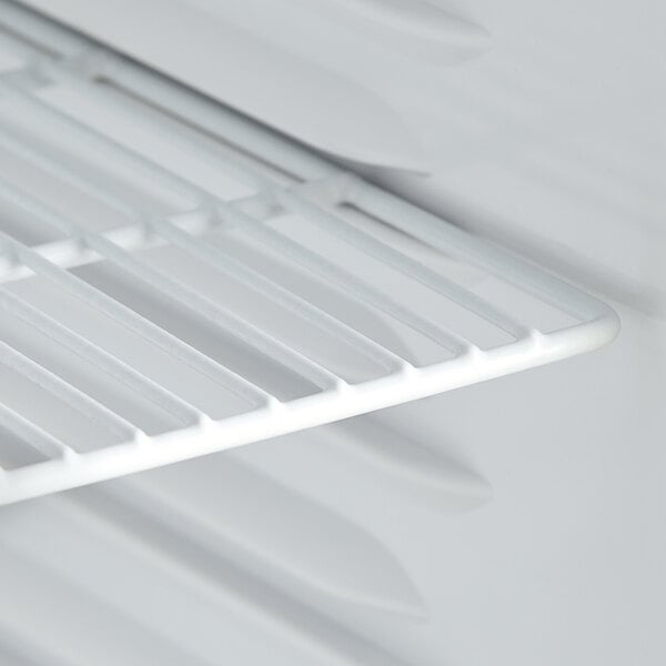 A white shelf inside an Avantco countertop display refrigerator.