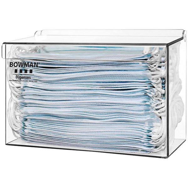 A clear plastic container with a stack of face masks.