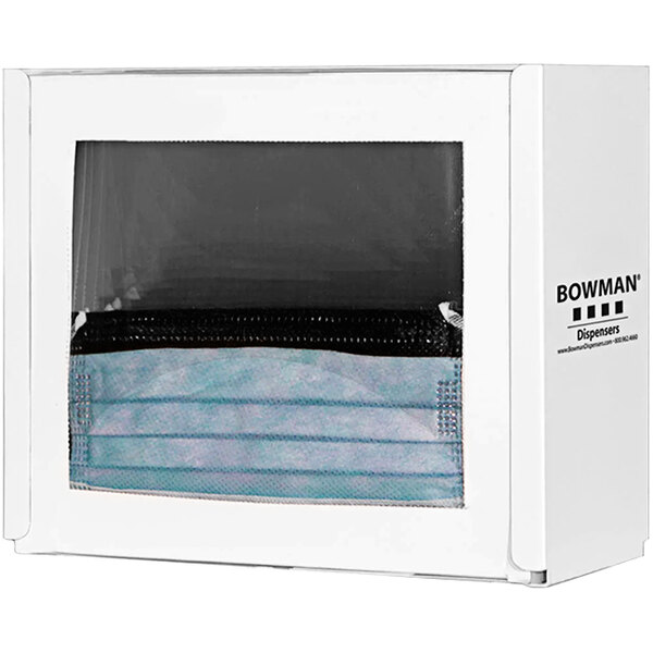 A white BOWMAN wall mount face mask dispenser with a face mask inside.