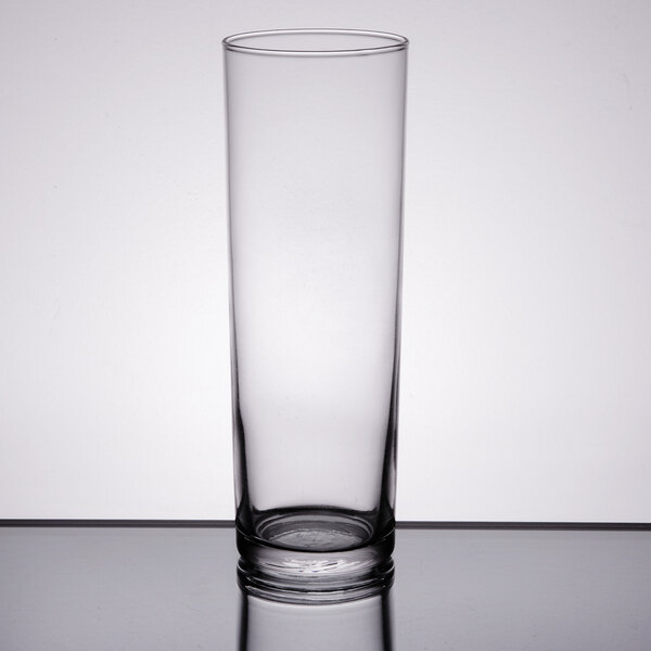 A Libbey Straight Sided Zombie Glass filled with water and a straw on a table.