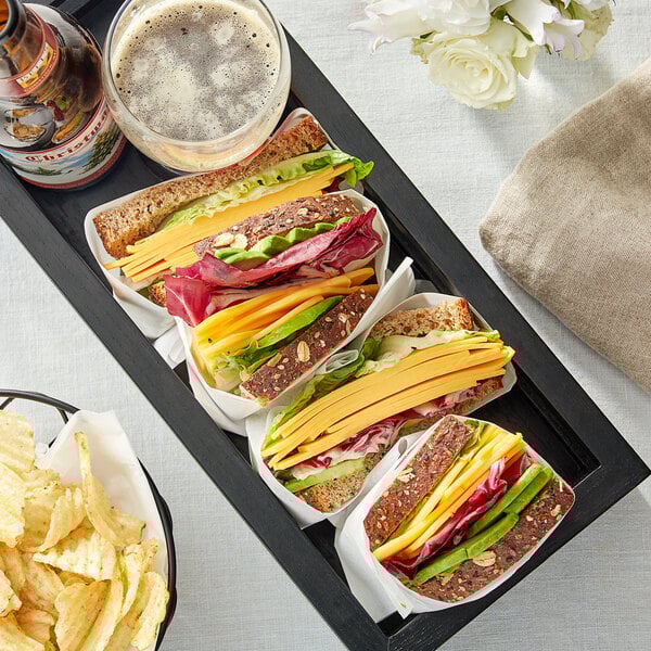 A tray of sandwiches with Follow Your Heart vegan cheese, lettuce, and avocado with chips.