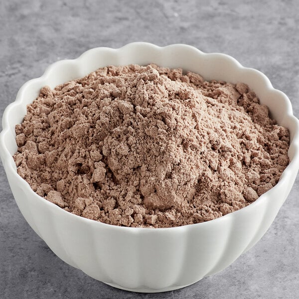 A bowl of brown Pillsbury Bakers' Plus Devil's Food Cake mix powder.