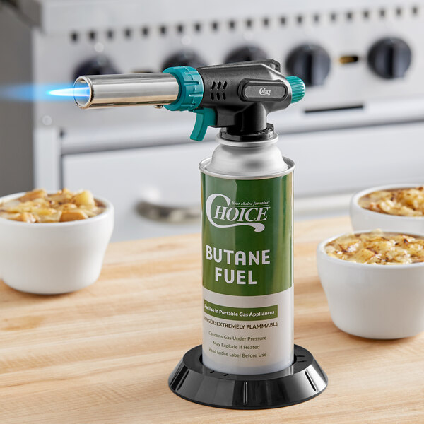 A green and white Choice Butane Fuel canister on a black base used to fuel a butane torch.