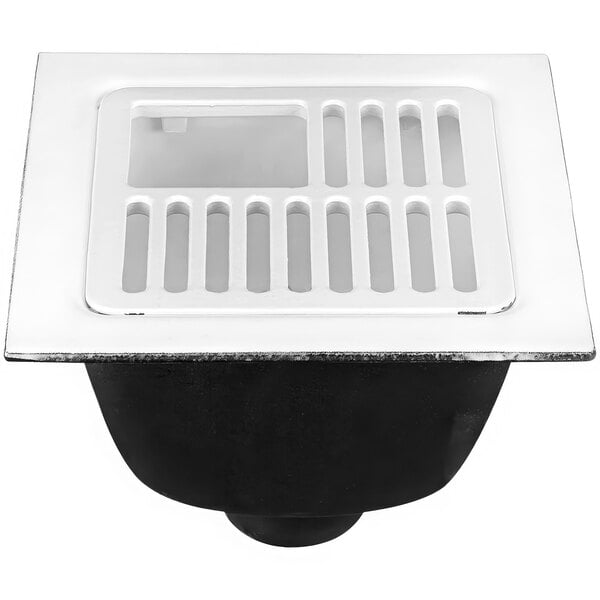 A white square floor sink with a plastic grate with holes.