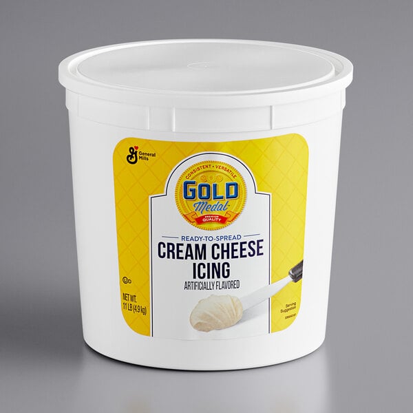 A white container of Gold Medal Ready-to-Spread Cream Cheese Icing with a yellow label and lid.