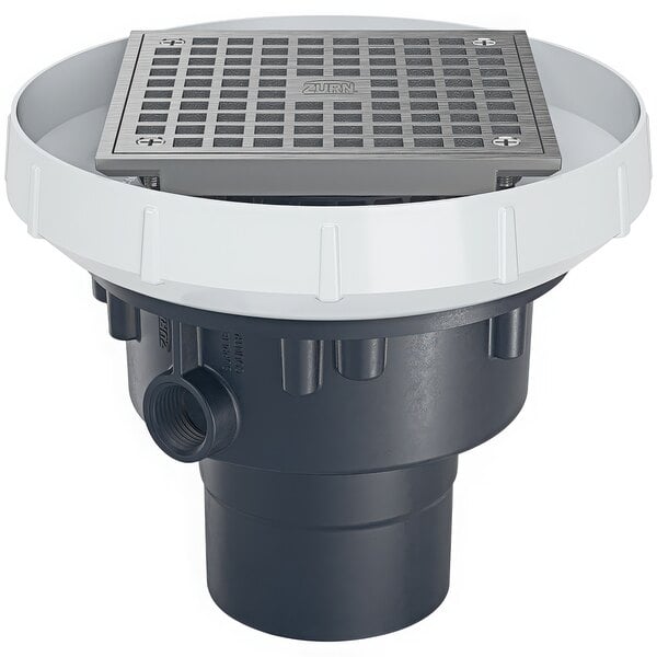 An Elkay floor drain with a round nickel bronze grate with holes in a white circle.