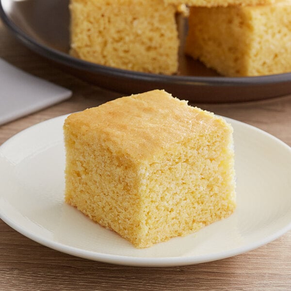 A piece of Gold Medal honey cornbread on a white plate.