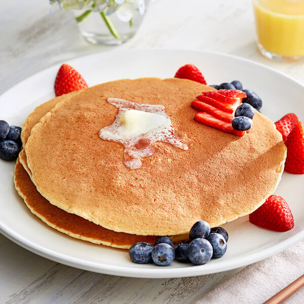 A plate of Gold Medal buttermilk pancakes with strawberries and blueberries.