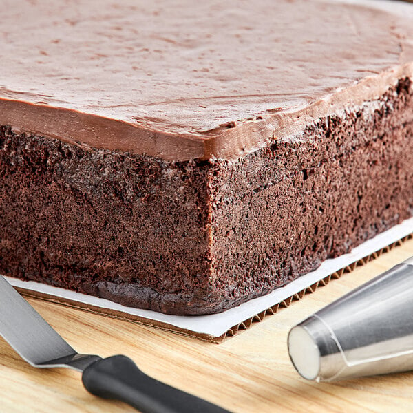 A close-up of a chocolate cake made with Gold Medal Devil's Food Cake Mix with frosting and a pastry bag.