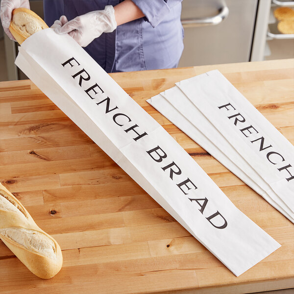 A person holding a Choice French Bread bag with a loaf of bread inside.