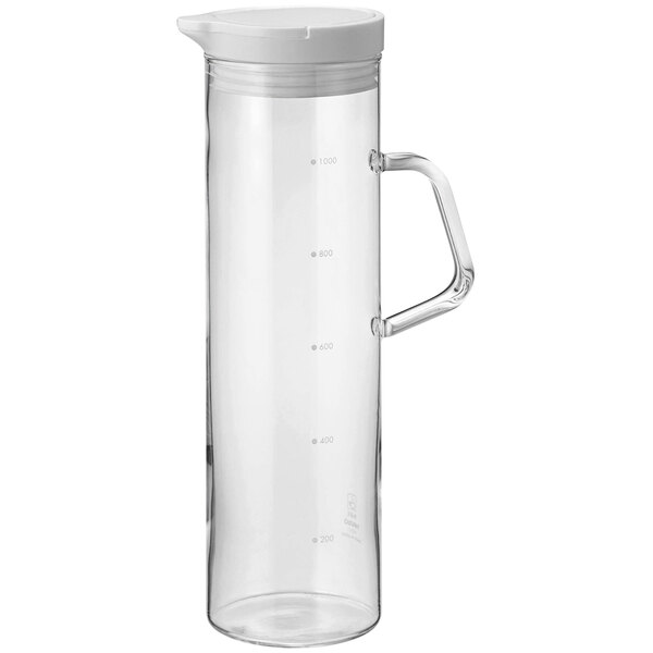 A clear glass pitcher with a handle and a white lid.