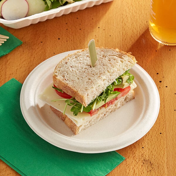 A sandwich on an EcoChoice natural bagasse blend plate with a drink.