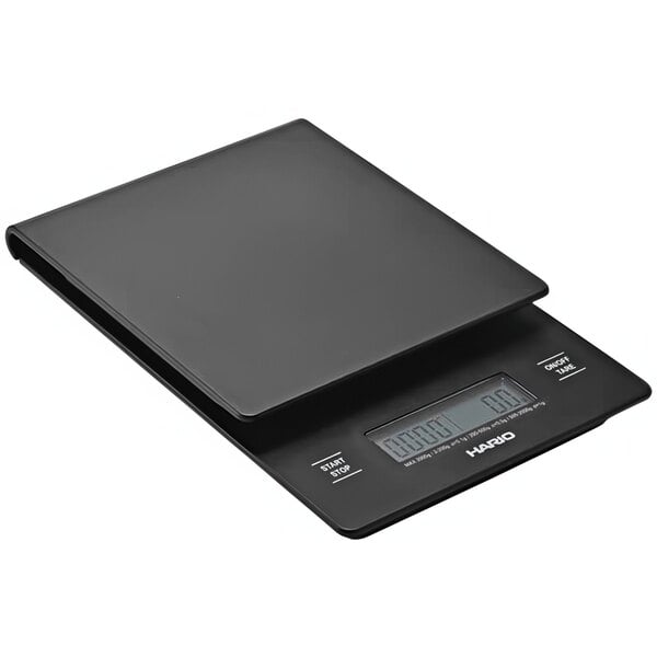 A black Hario V60 electronic drip scale on a table with a digital display.