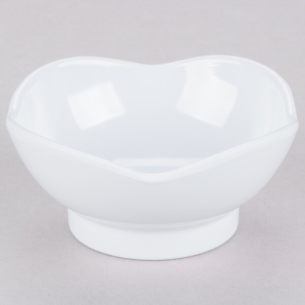 A white melamine bowl with a scallop shaped edge.